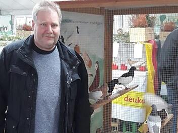 Vorsitzender des SV der Elsterpurzler, G&uuml;nter Vitzthum, vor einer Schauvoliere mit Elsterpurzlern. Foto: Rainer Wilm