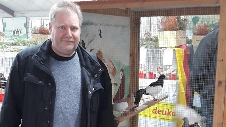 Vorsitzender des SV der Elsterpurzler, G&uuml;nter Vitzthum, vor einer Schauvoliere mit Elsterpurzlern. Foto: Rainer Wilm