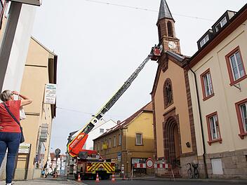 Eine Passantin beobachtet, was an der Uhr der Bürgerspitalkirche vor sich geht.  Foto: Arkadius Guzy