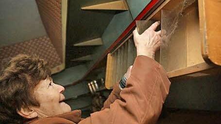 Ingeborg Pfriem zieht eine Scheibe aus dem Zigarettenregal heraus.