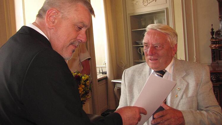 Oberbürgermeister Norbert Tessmer (links) überreicht dem ehemaligen Ortssprecher von Lützelbuch und Vorsitzenden des Bürgervereins, Günter Lehmann, die Urkunde zur Stadtmedaille. Foto: Martin Koch