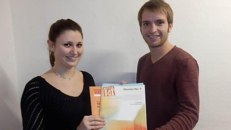 Corinna Seemann, 2. Vorsitzende der Notenkiller, nimmt von Sebastian Dees die gespendeten Noten entgegen. Foto: Blaskapelle