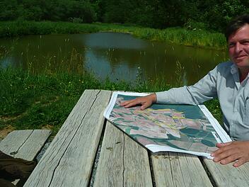 Sulzfelds B&uuml;rgermeister J&uuml;rgen Heusinger ist zufrieden mit dem "Boden-st&auml;ndig-Programm", das f&uuml;r weniger Bodenerosion sorgen soll. Im Fr&uuml;hjahr wurde beim Katzensteinsee ein Becken (siehe Foto) angelegt, in dem sich eingeschwemmte Erde absetzen soll. Foto: Michael Petzold