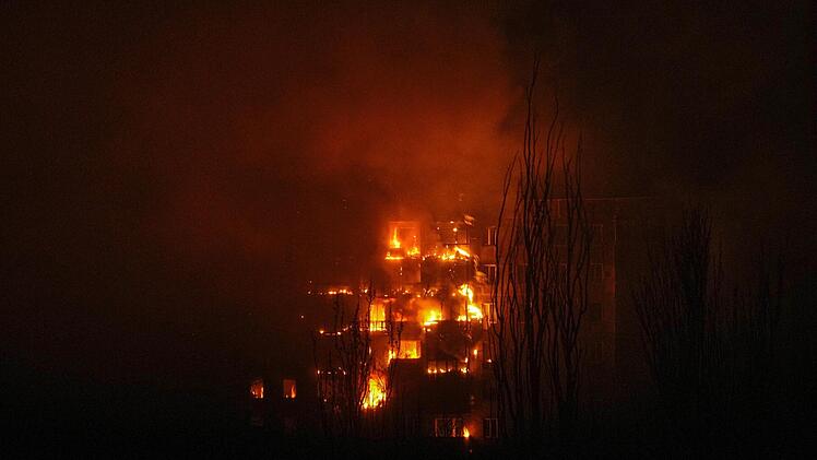 Ein Wohngebäude in Mariupol, das von einer Granate getroffen wurde, steht in Flammen.