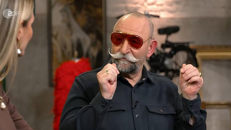 Der Gastgeber lie&szlig; sich nicht zweimal bitten: Kurzerhand setzte er das extravagante Modell selbst auf.