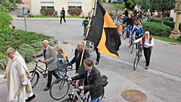 Mit 52 Radlern im Schlepptau, zog Pater Rudolf Theiler (vorne) unter den Klängen der Jugendblaskapelle mit einer Kirchenparade vom Dorfplatz zur Kirche.  Fotos: Helmut Will