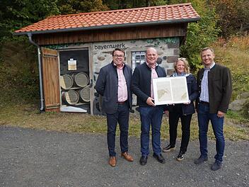 Vor 100 Jahren kam der Strom nach Oberweißenbrunn, Frankenheim und  Haselbach und damit auch an den Kreuzberg. Zur Erinnerung gab es für  Bürgermeister Georg Seiffert die Kopien der Originalverträge. Die  Übergabe fand vor der künstlerisch gestalteten Trafostation am Kreuzberg  statt (von links): Der neue Geschäftsführer der  Klosterbetriebe GmbH Christian Weghofer, Bürgermeister Georg Seiffert,  Christine Pfaff und Bernd Göttlicher. Foto: Marion Eckert
