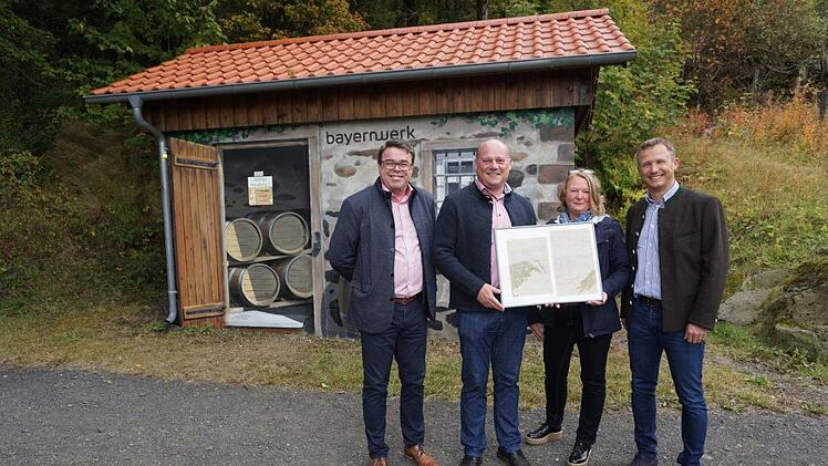 Vor 100 Jahren kam der Strom nach Oberweißenbrunn, Frankenheim und  Haselbach und damit auch an den Kreuzberg. Zur Erinnerung gab es für  Bürgermeister Georg Seiffert die Kopien der Originalverträge. Die  Übergabe fand vor der künstlerisch gestalteten Trafostation am Kreuzberg  statt (von links): Der neue Geschäftsführer der  Klosterbetriebe GmbH Christian Weghofer, Bürgermeister Georg Seiffert,  Christine Pfaff und Bernd Göttlicher. Foto: Marion Eckert