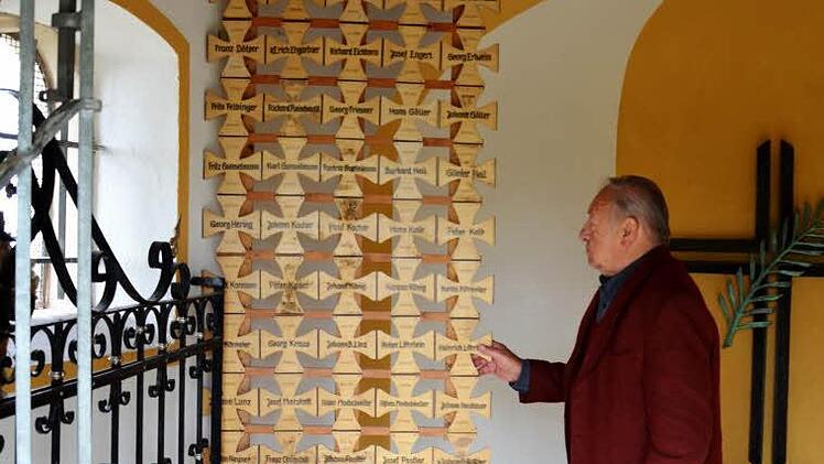 Herbert Karmann zeigt in der Buttenheimer Kriegergedächtnis-Kapelle die Erinnerungskreuze für die im 2. Weltkrieg umgekommenen Buttenheim. Eines davon erinnert auch an seinen eigenen Vater. Foto: Andrea Spörlein