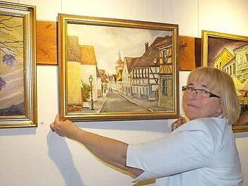 Maria Stawik-Höhlriegel bringt ein Bild mit Herzogenaurach-Motiv an.  Foto: Manfred Welker