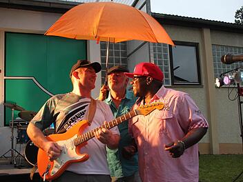 Gut beschirmt von Besucher Martin Knoch sangen und spielten Larry Rayford (rechts) und Stefan Kratofil von den "Orange Shakers" beim letztjährigen Sommerfest des Kleinkunstvereins "Tecnet Obermain". Für das diesjährige Sommerfest am 8. August wünschen sich die Musiker, dass sich diese Szene nicht wiederholen möge.  Foto: Stephan Stöckel