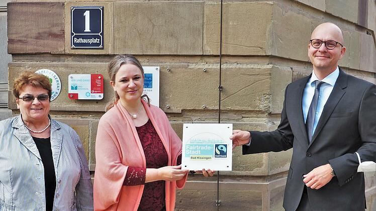Oberbürgermeister Dirk Vogel (SPD) brachte gemeinsam mit Susanne Wahler-Göbel (Mitte), Vorsitzende der lokalen Steuerungsgruppe, und Stadträtin Martha Müller (DBK), offizielle Vertreterin der Stadt in der Gruppe, die Plakette "Fairtrade-Stadt" am Rathaustor an.