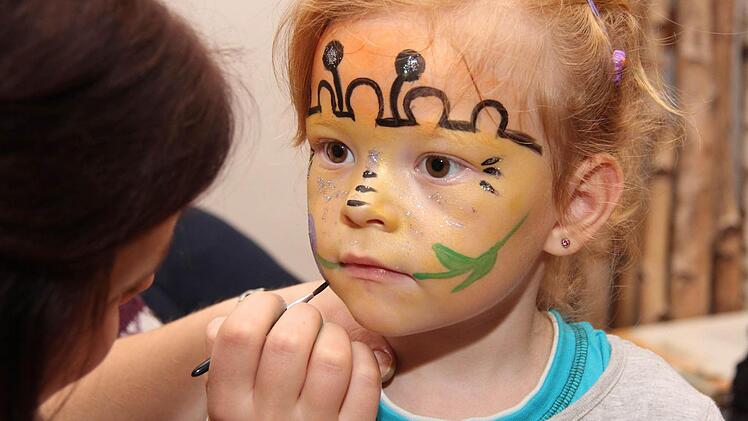 Kinderschminken bei Julia Keidel. Die dreijährige Sara genießt es.