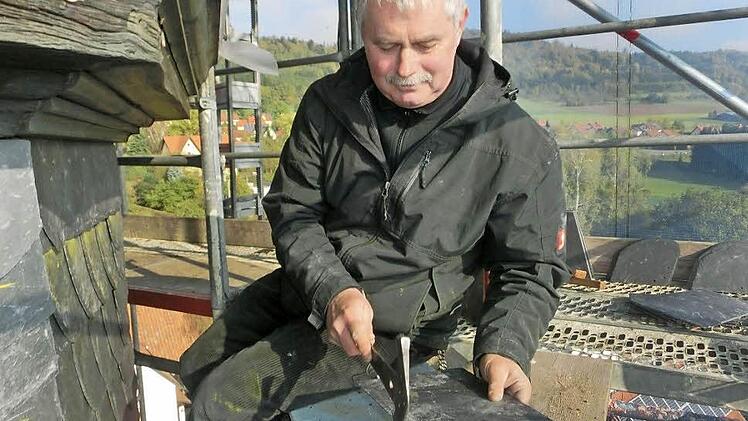 Ein Arbeitsplatz in luftiger Höhe: Bernd Voigt von der Firma Eber Bedachungen bringt eine Schieferplatte für die Turmfassade der St. Bartholomäus-Kirche in die richtige Größe. Fotos: Tobias Braunersreuther