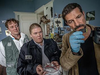 Kommissar Dupin (Pasquale Aleardi, rechts), Forensiker Frack (Jesse Albert) und Polizistin Nevou (Gisa Flake) untersuchen ein Zimmer der ermordeten Witwe Joelle, einer Vogelliebhaberin.