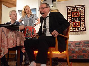 Der verflixte heiße Stuhl erhitzt Gemüter und Gesäß. Dies bekommt hier der Bankdirektor (Stefan Rubel) zu spüren. Er unterbreitet den Werkstattbesitzern (Joachim Blinzler und Claudia Blinzler) keine guten Nachrichten. Foto: Karl-Heinz Hofmann