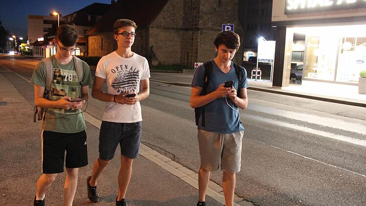 In ihre Smartphones vertieft (von links): Nick Niscior, Pascal Molendo und Dimitri Mazay auf dem Weg durch das nächtliche LichtenfelsFoto: Markus Häggberg