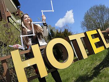 Eine fröhliche Hotel-Besitzerin: Angie Katze mit dem Zollstock vor ihrer Herberge in Fürth am Berg. Fotos: Matthias Hoch