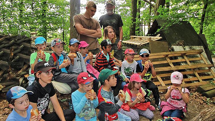 Die Kinder der evangelischen Kindertagesstätte, die in die Grundschule wechseln, waren von den Jägern zu einem Waldspaziergang eingeladen worden. Am Schluss gab es bei der Jagdhütte von Bernd Newiger noch Grillwürstchen. Im Hintergrund Moritz und Erich Schneider, die die Kinder zweieinhalb Stunden durch den Wald führten und ihnen viel zeigten.  Foto: Dieter Britz