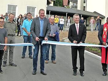 Zahlreiche Zaungäste verfolgten den gemeinsamen Scherenschnitt, mit dem (von links) Jens Kürschner, Bürgermeister Michael Keilich, Pfarrer Dirk Acksteiner und Pater Peter Uzor die östliche Friedhofszufahrt in Sonnefeld ihrer Bestimmung übergaben. Foto: Klaus Oelzner
