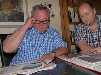 Bernd Faber (links) zeigt seinem Fraktionskollegen André Karl blättern in den Unterlagen über die Gemeinderatsarbeit der SPD in Weidhausen. Dabei wird deutlich: Die Stimmung im Gremium war schon einmal besser als sie heute ist. Foto: Berthold Köhler