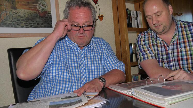 Bernd Faber (links) zeigt seinem Fraktionskollegen André Karl blättern in den Unterlagen über die Gemeinderatsarbeit der SPD in Weidhausen. Dabei wird deutlich: Die Stimmung im Gremium war schon einmal besser als sie heute ist. Foto: Berthold Köhler