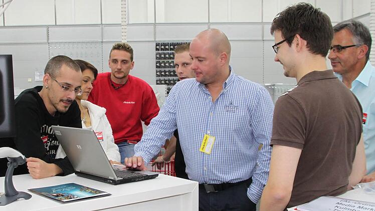 Im großen Verkaufsraum werden Mitarbeiter geschult, ...