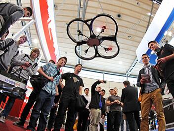 Die AR.Drone2.0 von Parrot, gesteuert von Pilot Jan Hendrik Hemme (rechts) in Action: Das hochkomplexe Spielzeug kann sich nicht nur selbstständig vorm Abstürzen schützen. Es zeichnet den Flug in HD-Qualität auf Video auf. Foto: Tobias Stich