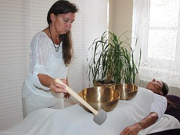 Wenn Judith Beuschel die Klangschalen anschlägt, nimmt der Körper von Klientin Michaela Eibert die Schwingungen auf.  Foto: Andreas Dorsch