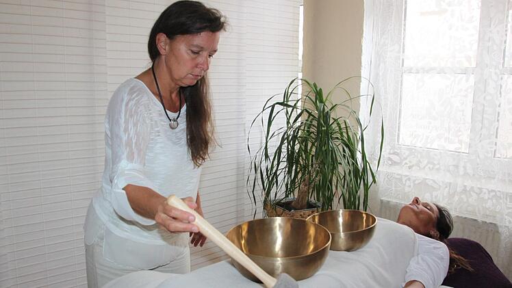 Wenn Judith Beuschel die Klangschalen anschlägt, nimmt der Körper von Klientin Michaela Eibert die Schwingungen auf.  Foto: Andreas Dorsch