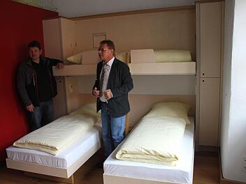 Herbergsvater Hubert Backer (links) und Bürgermeister Wolfgang Beiergrößlein freuen sich über die hochwertige Möblierung im Westflügel der Festungsherberge. Das obere Bett kann nach oben geklappt, die beiden unteren Betten können kuschelig zusammengerückt werden. Hinter der roten Wand befindet sich die Nasszelle.  Fotos: Friedwald Schedel