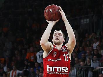 Wie fast alle Basketballer aus den baltischen Staaten ist Janis Strelnieks ein begnadeter Distanzwerfer. Hier netzt der Lette bei einem Pokalspiel im Februar 2015 in Ulm ein; hinten Trainer Andrea Trinchieri, der zusammen mit Strelnieks im Jahr zuvor nach Bamberg gekommen war. Fotos: Daniel Löb (2)/imago