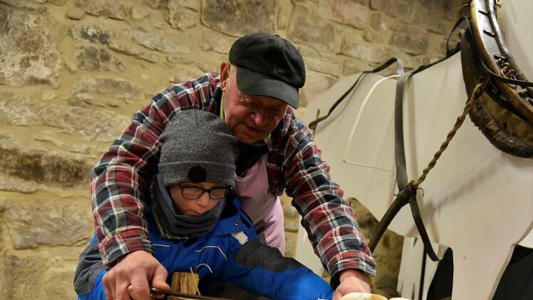 Auch mitmachen dürfen die Besucher beim Schlenkermarkt: So hobelt Felix  unter der Anleitung von Gustav Luthardt, bis die Späne fliegen. Foto: Gabi Arnold