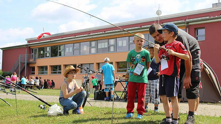 Fachsimpeln: Daniel Greul vom Angelverein Breitbrunn und Simon sprachen &uuml;ber die richtige Schnur f&uuml;r Karpfen. Jason und Leon h&ouml;rten zu.
