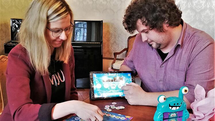 Philipp Pfülb (rechts), Referatsleiter Jugend, Familie und Soziales, und seine Kollegin Carolin Schaupp testen ein neues digital-analoges Kombinationsspiel mit Tablet und Spielbrett.  Fotos: Sigismund von Dobschütz