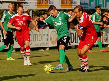 Der Sander Sebastian Götz (Mitte, grünes Trikot) im Duell mit Gästekapitän Julian Grell.
