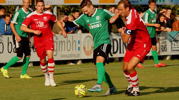 Der Sander Sebastian Götz (Mitte, grünes Trikot) im Duell mit Gästekapitän Julian Grell.