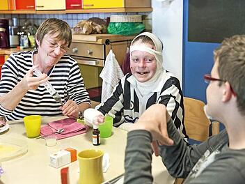 Entspannte Stimmung am Abendbrottisch: Während die anderen Internatsmitbewohner essen, kümmert sich die Betreuerin um Patricks Versorgung durch die Magensonde.  Fotos: Hagen Lehmann