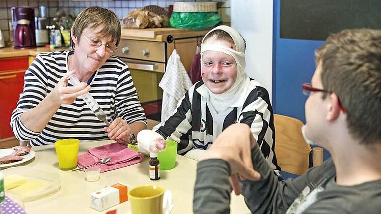 Entspannte Stimmung am Abendbrottisch: Während die anderen Internatsmitbewohner essen, kümmert sich die Betreuerin um Patricks Versorgung durch die Magensonde.  Fotos: Hagen Lehmann