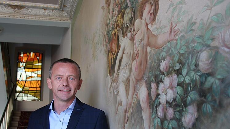 Waldemar Michaelis im Eingangsbereich der Villa Ross mit den charakteristischen  Wandgemälden. Borst
