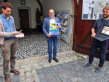 Das Ferienprogramm stellten Bürgermeister Michael Kastl (Mitte) mit dem  Plakat, Nikolas Zenzen (links) mit Blick auf sein Smartphone und Kilian  Düring (rechts) auf seinem Laptop vor. Gedruckte Programme gibt es dieses  Jahr wegen der Corona-Pandemie nicht.  Foto: Dieter Britz