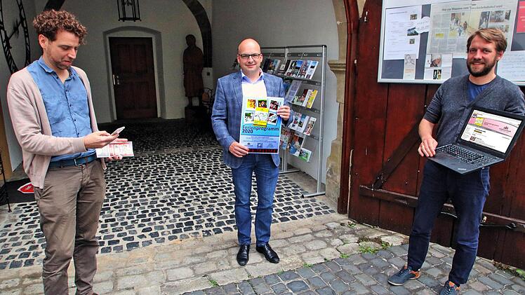 Das Ferienprogramm stellten Bürgermeister Michael Kastl (Mitte) mit dem  Plakat, Nikolas Zenzen (links) mit Blick auf sein Smartphone und Kilian  Düring (rechts) auf seinem Laptop vor. Gedruckte Programme gibt es dieses  Jahr wegen der Corona-Pandemie nicht.  Foto: Dieter Britz