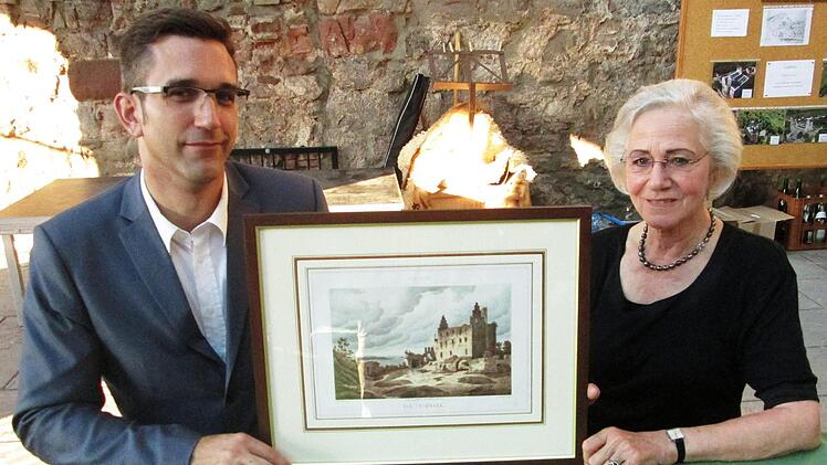 Ingrid Reinisch (rechts) überraschte den Vorsitzenden der Trimburgfreunde, Micha Strauß mit einer Original-Radierung des Malers August Geist.  Fotos: Winfried Ehling