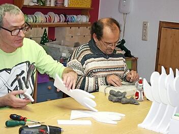 Michael und Udo arbeiten konzentriert an ihren Filzm&auml;usen und Holzengeln.  Foto: Maria L&ouml;ffler
