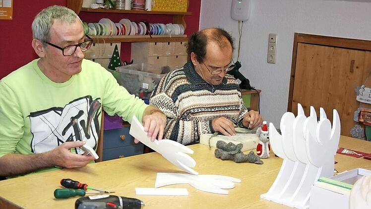 Michael und Udo arbeiten konzentriert an ihren Filzm&auml;usen und Holzengeln.  Foto: Maria L&ouml;ffler