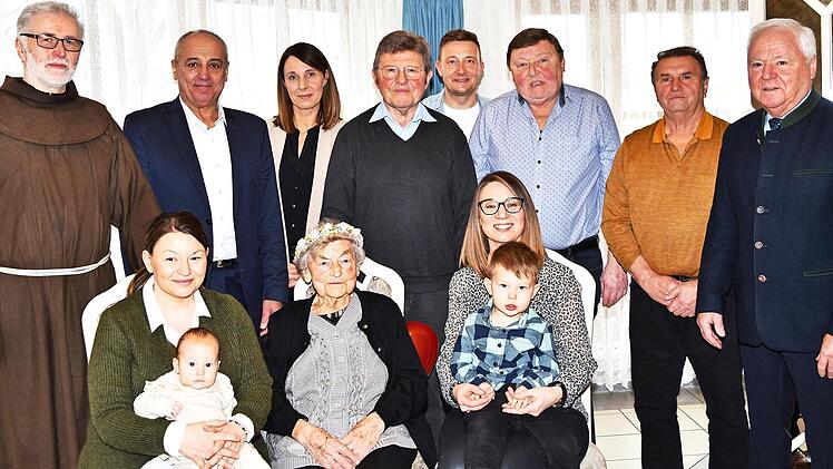 Tina Jungkunz (vorn Mitte) an ihrem 95. Geburtstag mit ihren beiden Söhnen Edwin und Wilmar (Bildmitte v. l.), deren Familien und Angehörigen sowie Pater Rufus (l.), Bürgermeister Robert Hümmer (Zweiter v. l.) und stellvertretendem Landrat Helmut ...