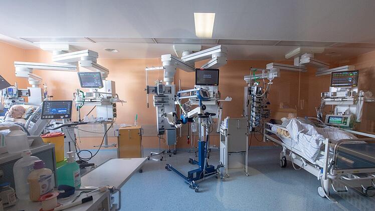 Zwei positiv getestete Corona-Patienten liegen in einem isoliertem Intensivbett-Zimmer. Die Vergütung für ihre Behandlung deckt nicht die Kosten. Peter Kneffel, dpa