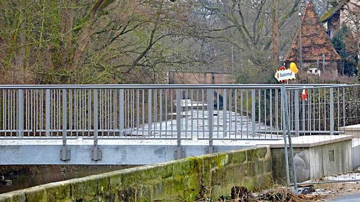 Heute steht ein neuer Steg aus Granit an der Stelle, der aber noch nicht freigegeben ist. Die Aurach ist durch den Uferbewuchs schmäler geworden, das Türmchen rechts steht noch immer.  Foto: bp
