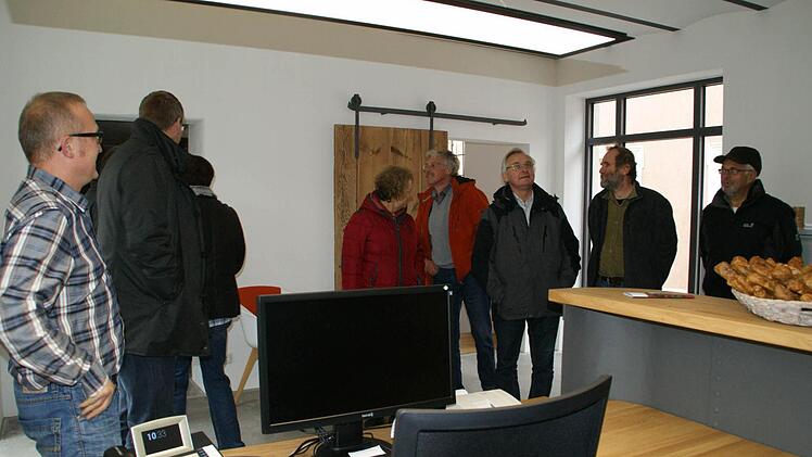 Wie man auch aus einem denkmalgeschützten Industriebau ein Gebäude mit ganz besonderen Qualitäten machen kann, das erläuterte Hauseigentümer Olaf Ernst (links) den Teilnehmern der IlE-Energietour in Untersteinbach.