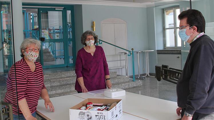 Marianne Kellner (links), Marianne Schmittlutz (Mitte) und Eduard Schmittlutz erproben das kontaktfreie Ausgabesystem in Eltmanner Stadthalle. Dort haben sie in Zeiten von Corona mehr Platz und k&ouml;nnen so den Abstand wahren.  Fotos: Sven D&ouml;rr